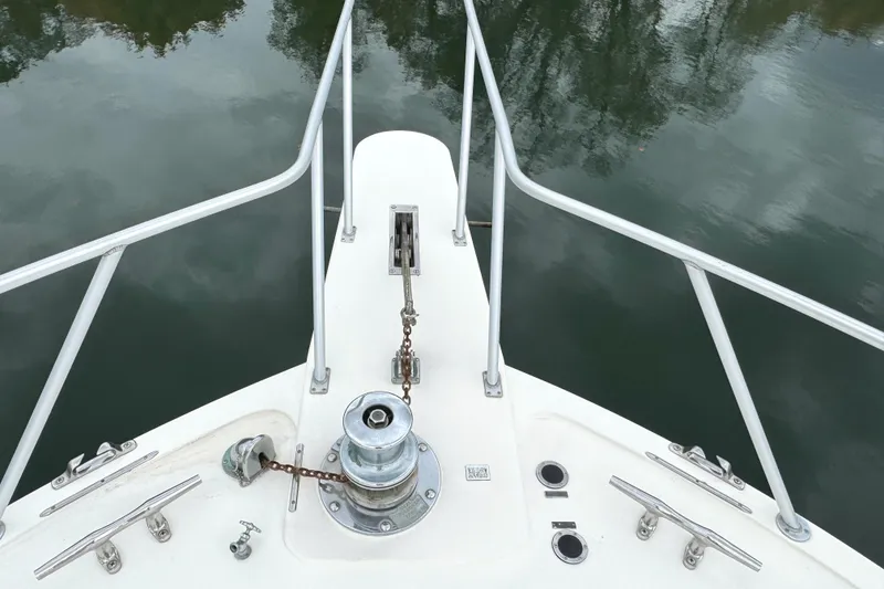 Slide: The Image of 1991 Viking 53 Convertible yacht deck with railing, near a calm shoreline. - 81