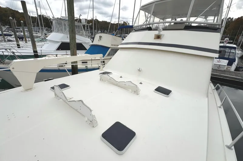 Slide: The Image of 1991 Viking 53 Convertible yacht docked at marina under cloudy skies. - 84