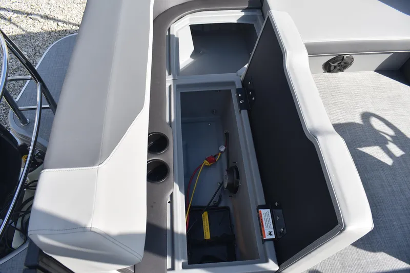 Slide: The Image of Open storage compartment in 2026 Lowe LS 210 boat, featuring cup holders and wiring. - 19