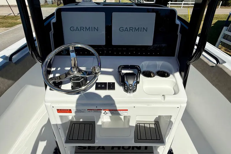 Slide: The Image of 2026 Sea Hunt Ultra 265 SE boat dashboard with Garmin displays and steering wheel. - 10