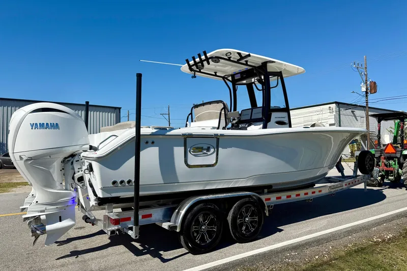 Slide: The Image of 2026 Sea Hunt Ultra 265 SE boat on trailer with Yamaha engine, parked outdoors. - 4