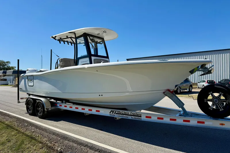 Slide: The Image of 2026 Sea Hunt Ultra 265 SE boat on trailer, parked outdoors under clear blue sky. - 5