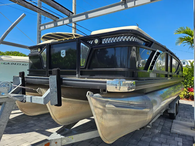 Slide: The Image of 2020 Godfrey Sanpan 2400 SBC pontoon boat on trailer, parked outdoors. - 2