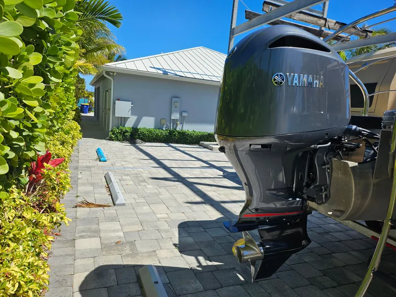 Slide: The Image of Outboard motor on a 2020 Godfrey Sanpan 2400 SBC, parked on a sunny driveway. - 31