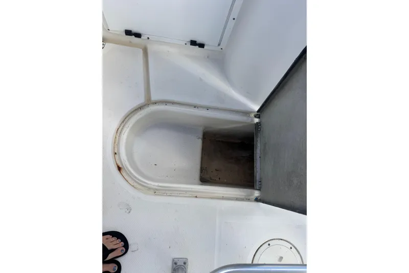Slide: The Image of 2002 Aquasport 225 Osprey boat interior showing storage compartment and deck details. - 24