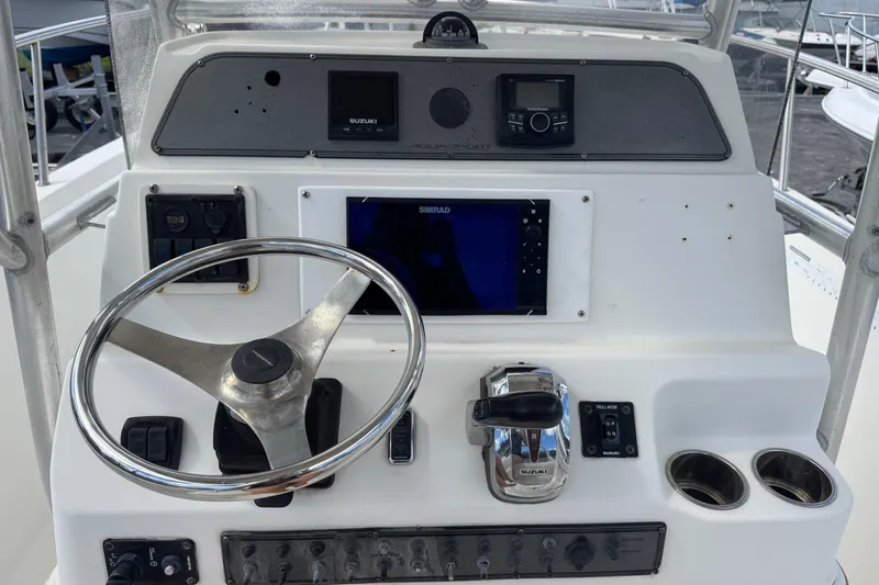 Slide: The Image of 2002 Aquasport 225 Osprey boat dashboard with steering wheel and navigation controls. - 8