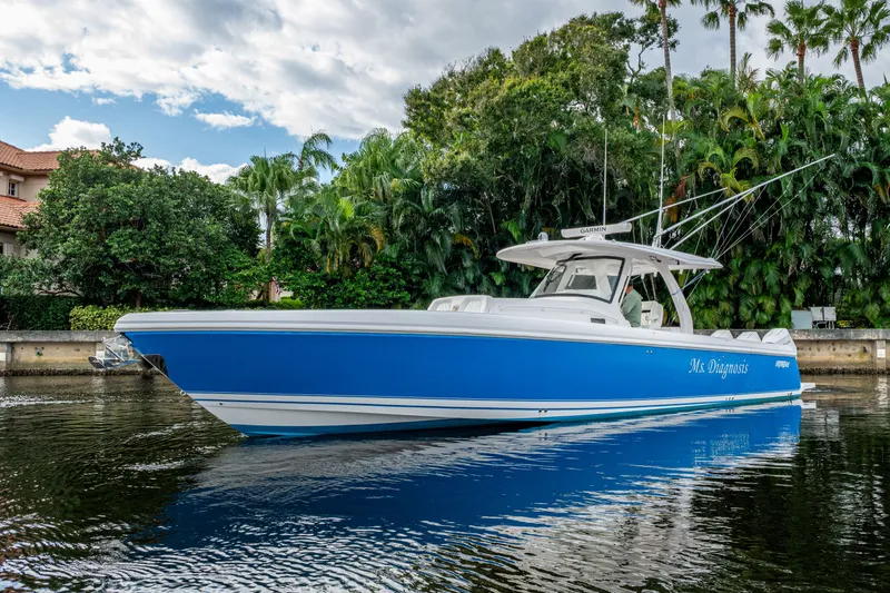 Slide: The Image of 2020 Intrepid 407 Panacea boat on water, surrounded by lush greenery and clear skies. - 1