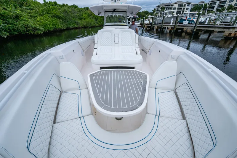 Slide: The Image of 2020 Intrepid 407 Panacea boat with luxurious seating and sleek design at a marina. - 18
