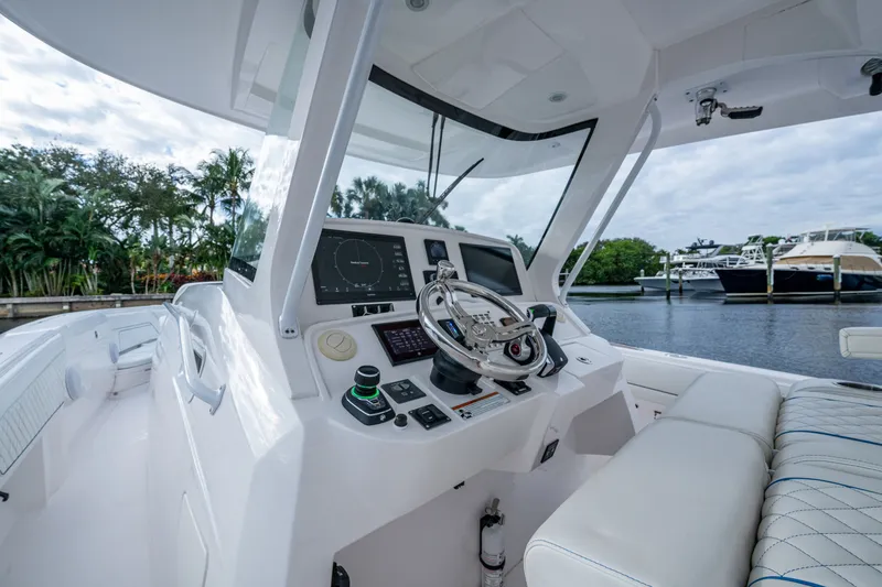 Slide: The Image of Cockpit of 2020 Intrepid 407 Panacea boat with modern controls and waterfront view. - 2
