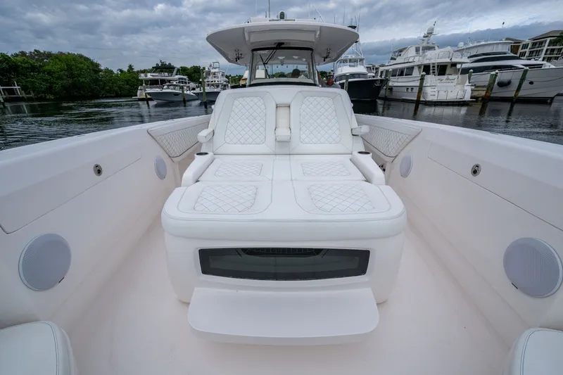 Slide: The Image of 2020 Intrepid 407 Panacea boat with luxurious white seating in a marina setting. - 20