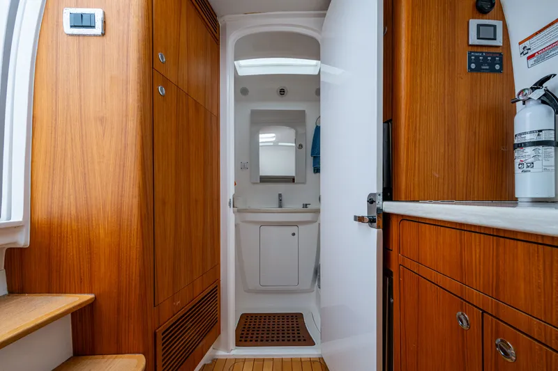 Slide: The Image of Interior of 2020 Intrepid 407 Panacea boat, featuring wooden cabinetry and compact bathroom. - 25