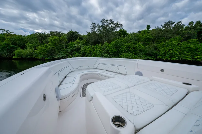 Slide: The Image of Luxurious seating on 2020 Intrepid 407 Panacea boat, surrounded by lush greenery. - 31