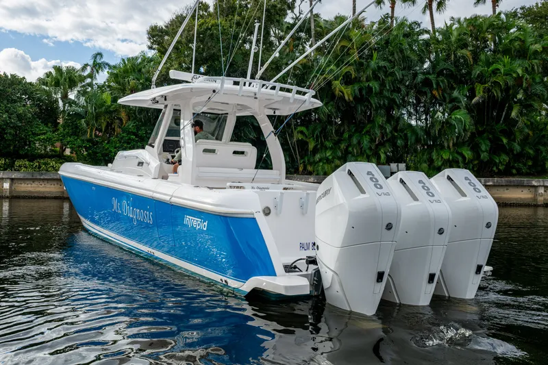 Slide: The Image of 2020 Intrepid 407 Panacea boat with triple outboard engines on a calm waterway. - 35