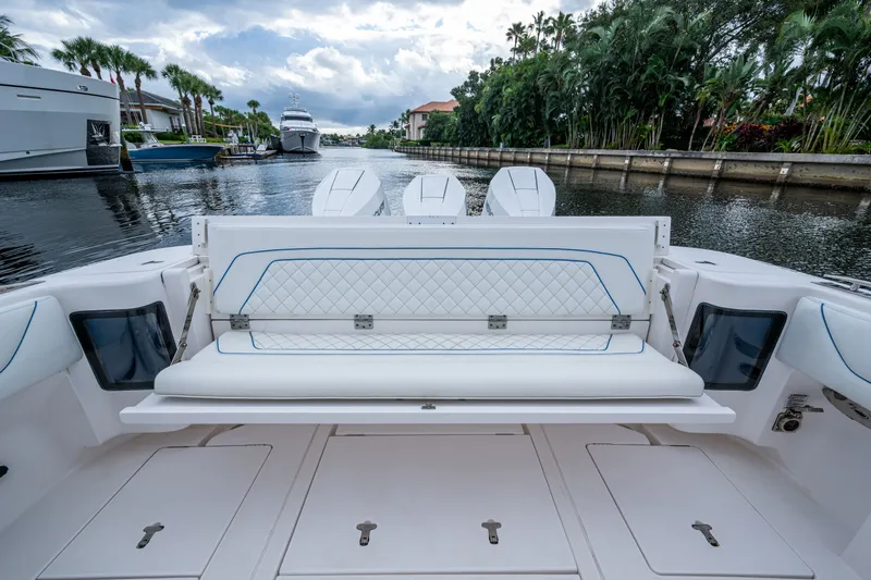 Slide: The Image of 2020 Intrepid 407 Panacea boat with luxurious seating and powerful engines docked by palm trees. - 8