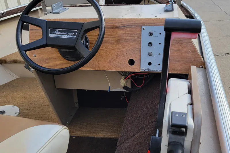 Slide: The Image of 1987 Alumacraft Classic 165 CS boat dashboard with steering wheel and control panel. - 16