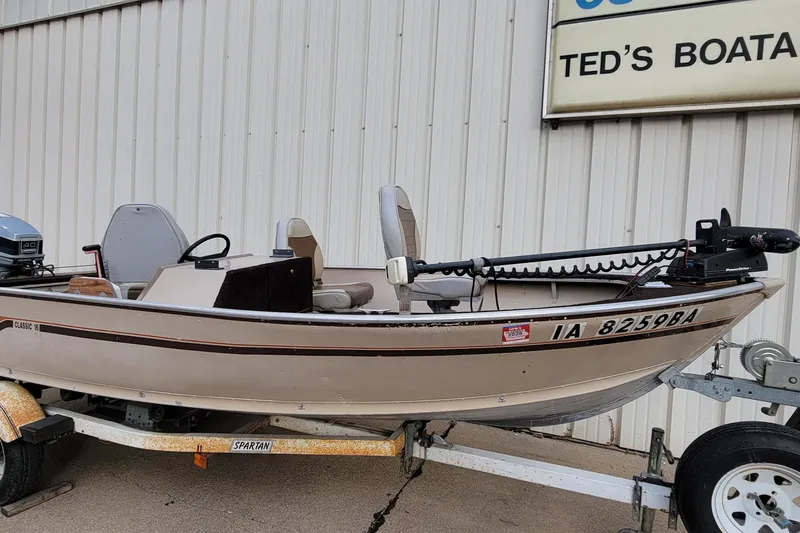Slide: The Image of 1987 Alumacraft Classic 165 CS boat on trailer, parked outside Ted's Boating. - 2