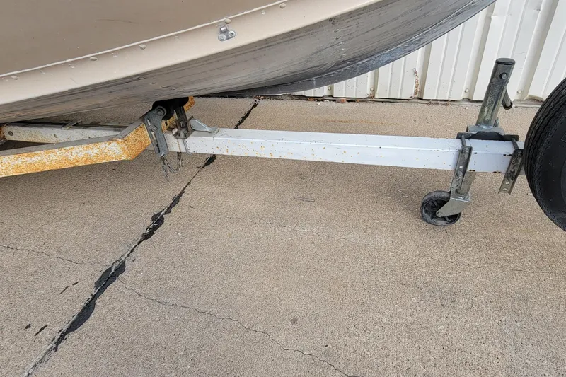 Slide: The Image of 1987 Alumacraft Classic 165 CS boat trailer with visible rust on concrete surface. - 21