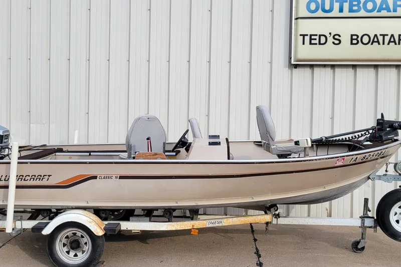 Slide: The Image of 1987 Alumacraft Classic 165 CS boat on trailer, parked outside Ted's Boatarama. - 3
