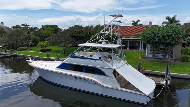 The Image of 1991 Donzi 65 Sportfisherman yacht docked near a waterfront home. - 0