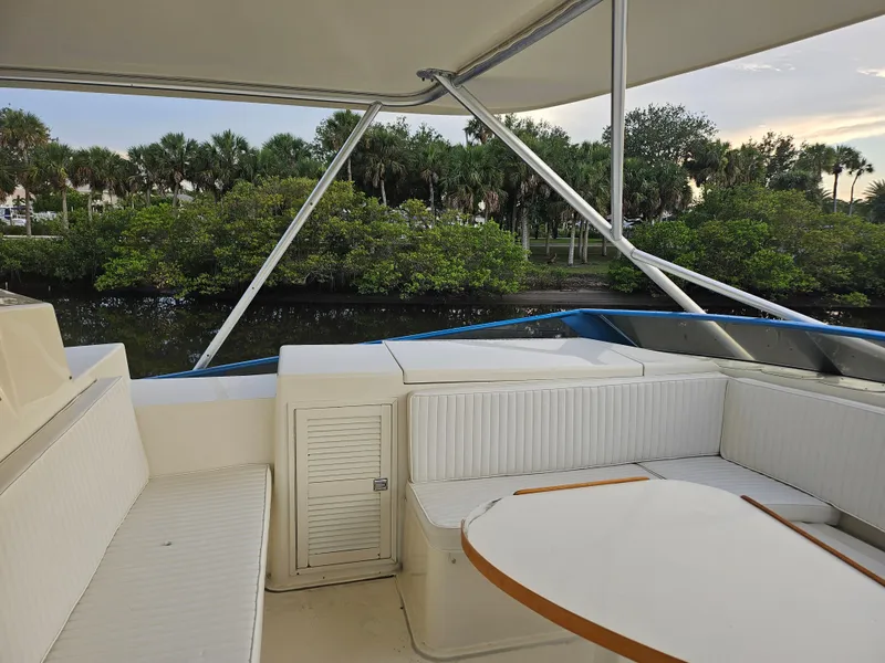 Slide: The Image of 1991 Donzi 65 Sportfisherman yacht deck with white seating and table. - 19