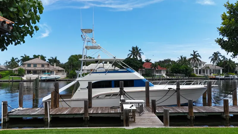 Slide: The Image of 1991 Donzi 65 Sportfisherman docked at a marina with waterfront homes in the background. - 30