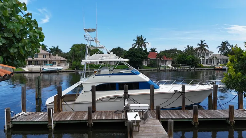 Slide: The Image of 1991 Donzi 65 Sportfisherman yacht docked at a marina with waterfront homes. - 31