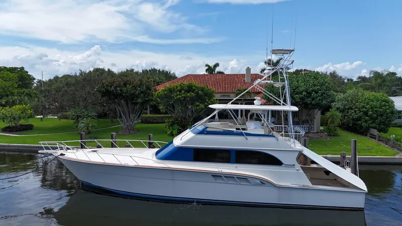 Slide: The Image of 1991 Donzi 65 Sportfisherman yacht docked near a lush, green waterfront property. - 36