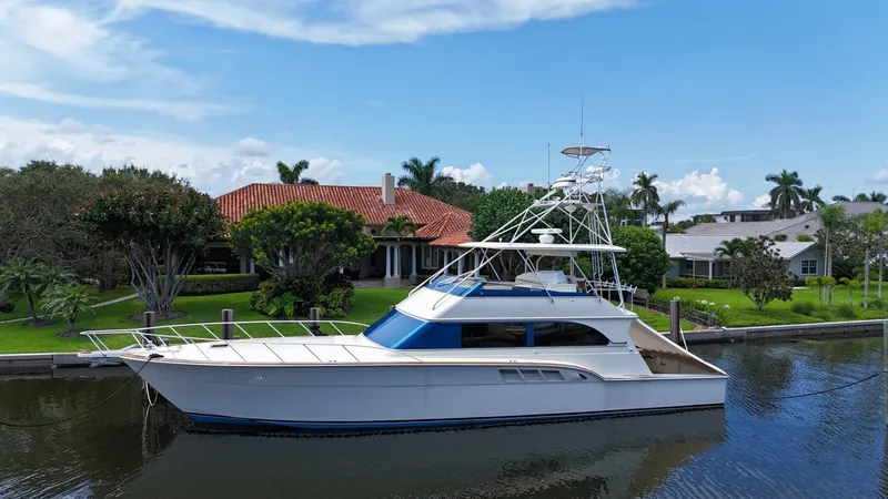 Slide: The Image of 1991 Donzi 65 Sportfisherman yacht docked by a waterfront home. - 47