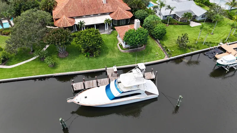 Slide: The Image of Aerial view of a 1991 Donzi 65 Sportfisherman docked by a waterfront home. - 48