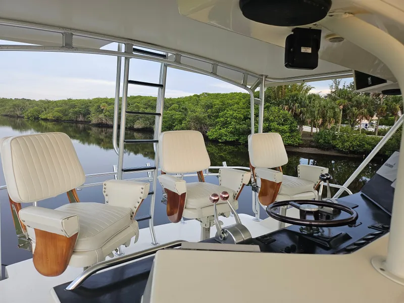 Slide: The Image of 1991 Donzi 65 Sportfisherman boat interior with white captain chairs and steering wheel. - 9