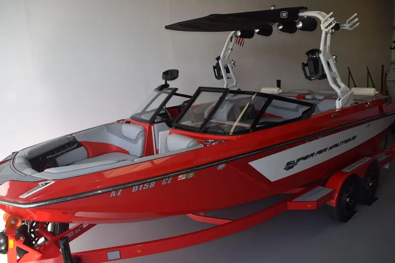 The Image of 2021 Nautique Super Air Nautique GS22 boat in red, parked indoors. - 0