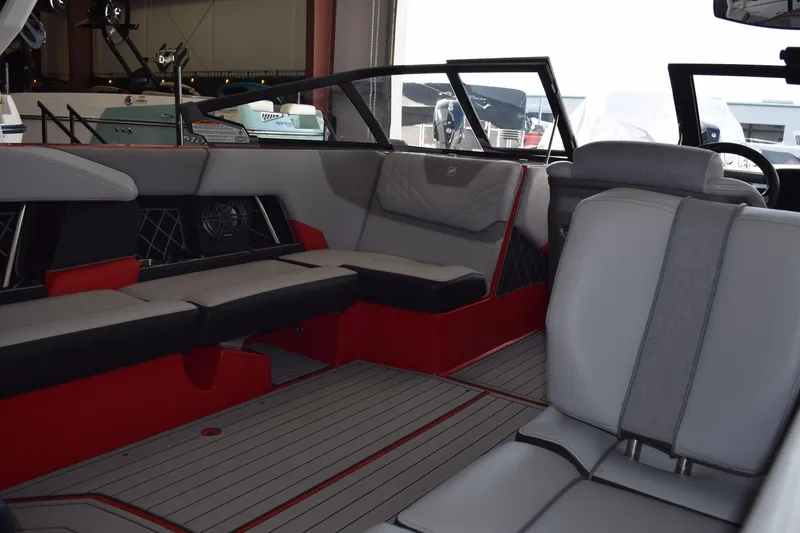 Slide: The Image of 2021 Nautique Super Air Nautique GS22 interior with gray and red seating. - 12