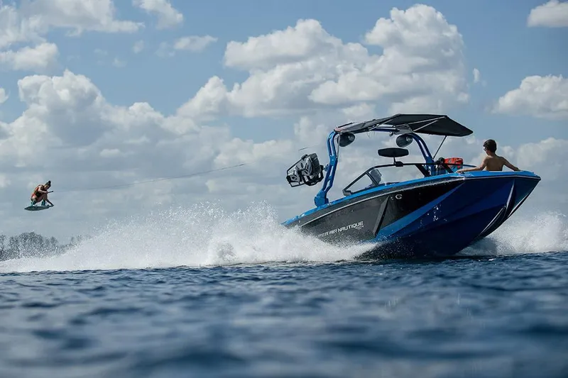 Slide: The Image of Manufacturer Provided Image: 2021 Nautique Super Air Nautique GS22 towing a wakeboarder on a sunny day. - 16