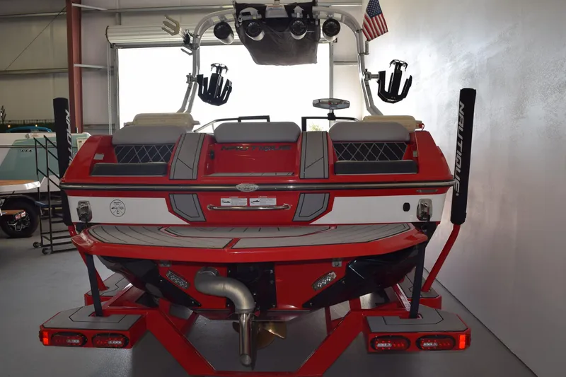 Slide: The Image of 2021 Nautique Super Air Nautique GS22 boat, red and white, in a garage setting. - 2