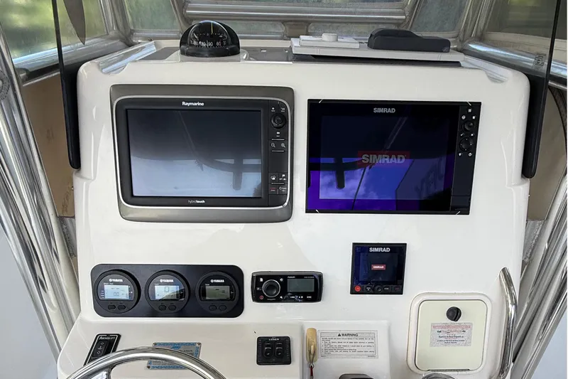 Slide: The Image of 2008 Century 2901 Center Console dashboard with Raymarine and Simrad navigation systems. - 31