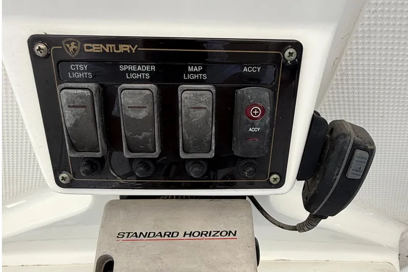 Slide: The Image of Control panel of a 2008 Century 2901 Center Console boat with light switches and radio. - 40