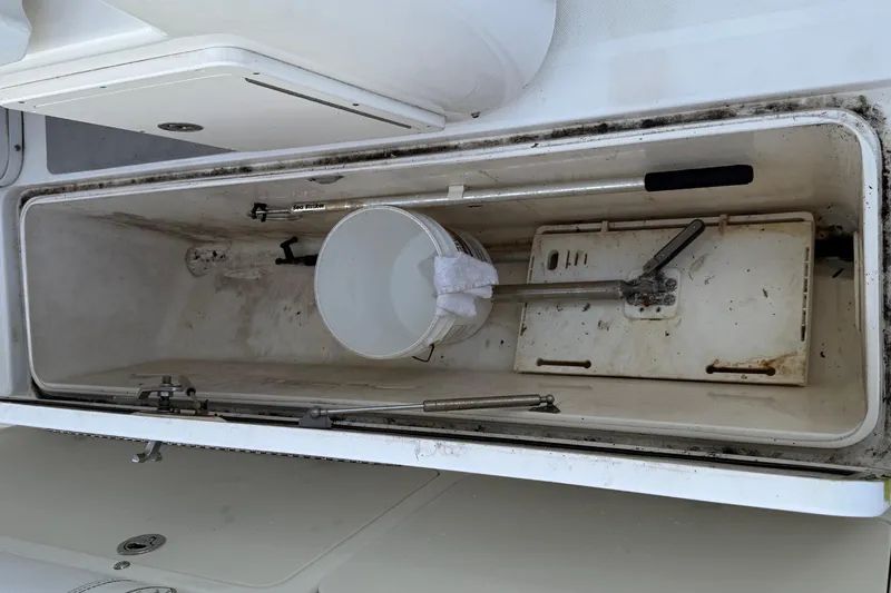 Slide: The Image of Open storage compartment on 2008 Century 2901 Center Console boat with tools and bucket. - 61