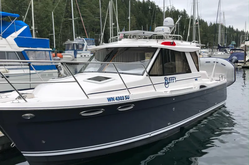 Slide: The Image of 2020 Cutwater C-28 boat docked in a marina, surrounded by other vessels. - 2
