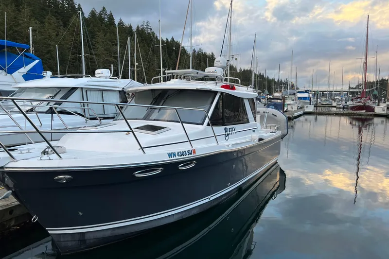 Slide: The Image of 2020 Cutwater C-28 boat docked in a marina with surrounding sailboats. - 3
