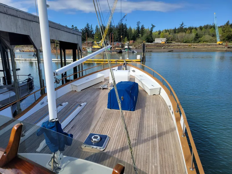Slide: The Image of 1982 Miller Marine North Sea Trawler docked, showcasing spacious wooden deck and serene waterfront. - 15