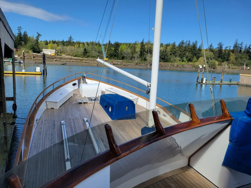Slide: The Image of 1982 Miller Marine North Sea Trawler docked, showcasing wooden deck and serene waterfront view. - 16