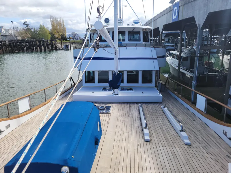 Slide: The Image of 1982 Miller Marine North Sea Trawler with wooden deck, docked near a marina. - 19