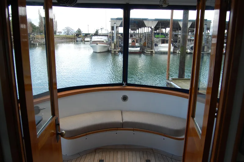 Slide: The Image of 1982 Miller Marine North Sea Trawler interior with curved seating, overlooking marina. - 37