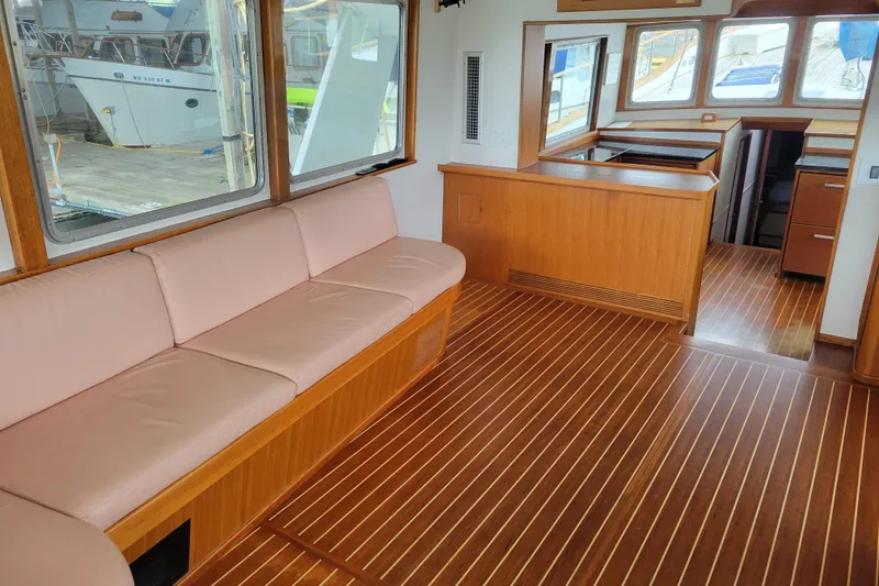 Slide: The Image of Interior of 1982 Miller Marine North Sea Trawler, featuring wood flooring and seating area. - 38