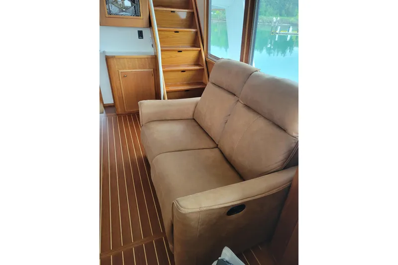 Slide: The Image of Interior of 1982 Miller Marine North Sea Trawler with brown sofa and wooden flooring. - 40