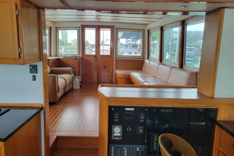 Slide: The Image of Interior of 1982 Miller Marine North Sea Trawler, featuring wood paneling and seating area. - 42