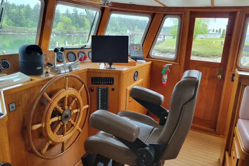 Slide: The Image of Interior of 1982 Miller Marine North Sea Trawler, featuring wooden helm and navigation equipment. - 83