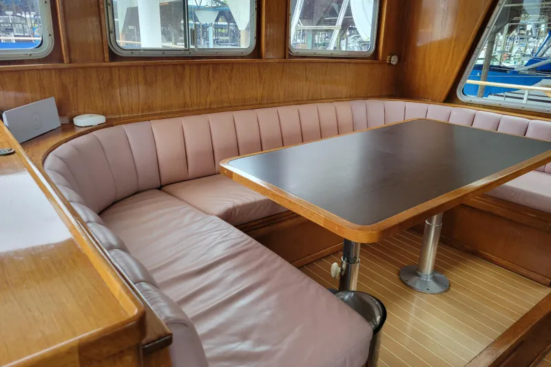 Slide: The Image of Cozy dining area in 1982 Miller Marine North Sea Trawler, featuring wood and leather seating. - 85
