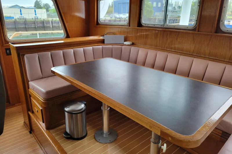 Slide: The Image of Interior of 1982 Miller Marine North Sea Trawler, featuring a cozy dining area with wood accents. - 87