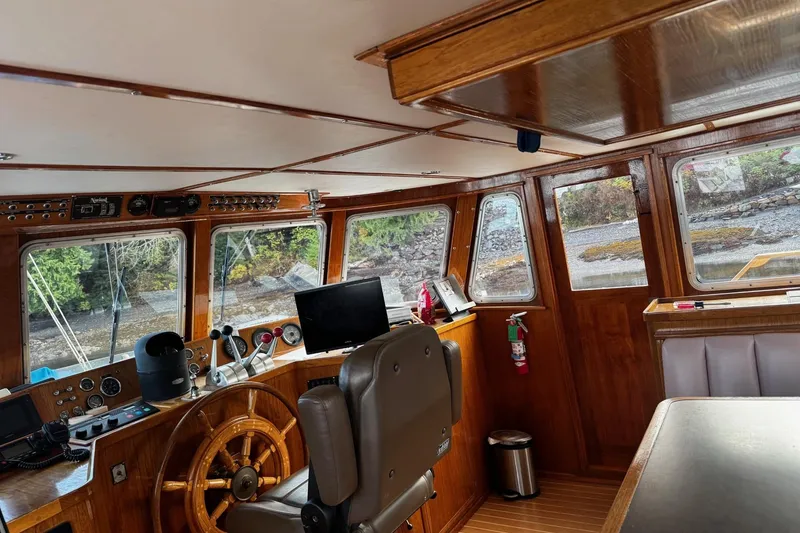 Slide: The Image of 1982 Miller Marine North Sea Trawler interior with wooden helm, navigation equipment, and large windows. - 89